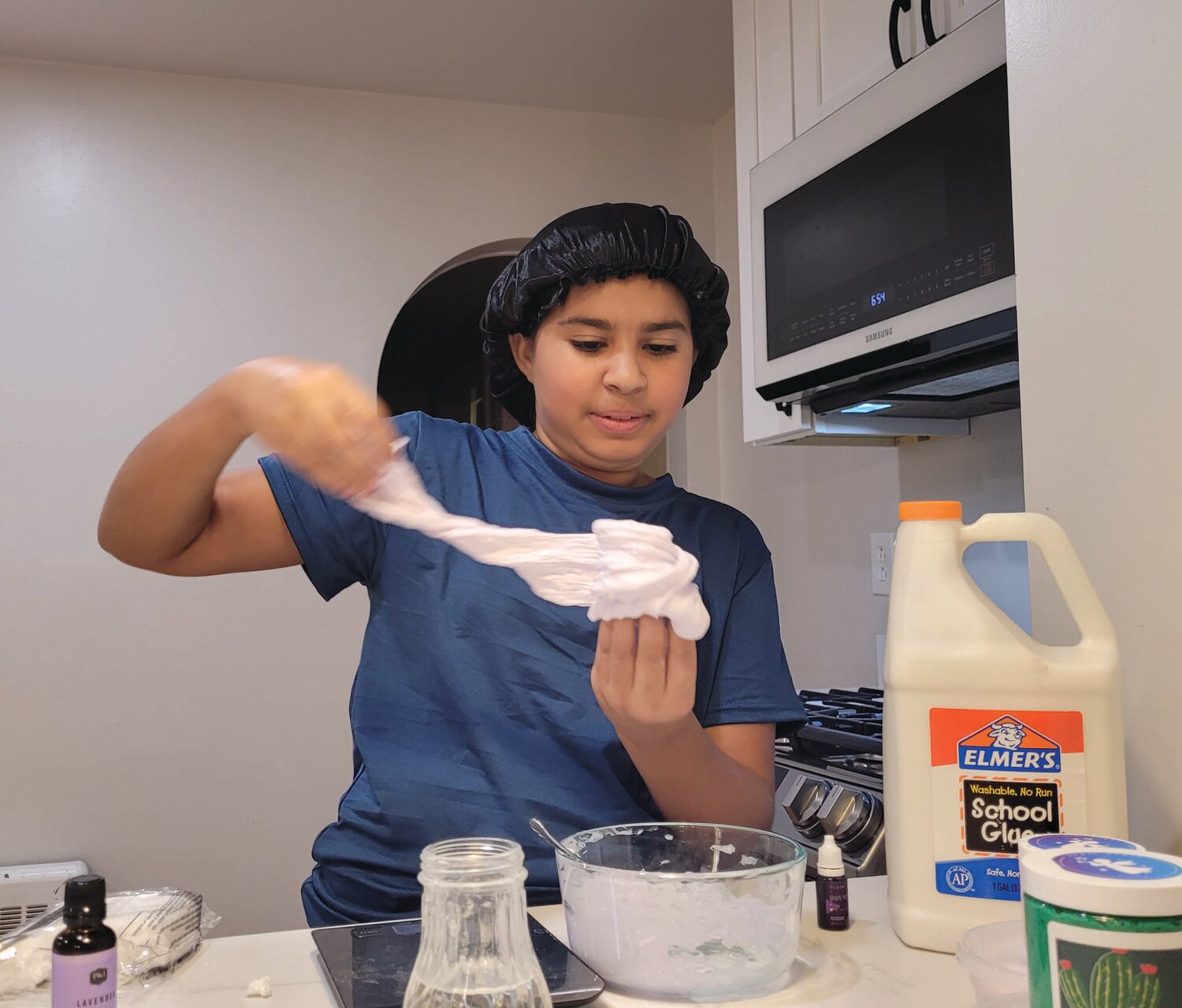 STRESS RELIEF: Santos needs to work the ingredients into the slime. Usually, she wears gloves while making slime for sale. Here, she demonstrates the technique on a sample batch.
